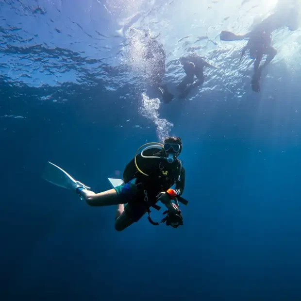 Advanced diver with personal gear and underwater camera